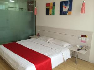 a bedroom with a large bed with a red blanket at Thank Inn Chain Hotel Hebei Cangzhou West Jiefang Road in Cangzhou