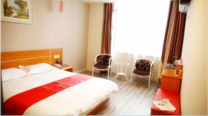 um quarto de hotel com uma cama e duas cadeiras em Thank Inn Chain Hotel Shandong ZaozhuangZhou North Tasi Road Government Affairs Center em Tengzhou