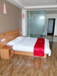 a bedroom with a bed with a red blanket on it at Thank Inn Chain Hotel Hebei Cangzhou Dongwaihuan International Hardware Plaza in Cangzhou