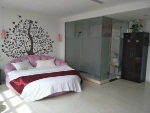 a bedroom with a large bed with a tree on the wall at Thank Inn Chain Hotel Hebei Zhangjiakou Guyuan County Yingbin Avenue in Guyuan