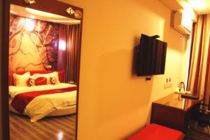 een kamer met een slaapkamer met een bed en een spiegel bij Thank Inn Chain Hotel Huebei Jinmen Jingshan County Chengzhong Road in Jingshan