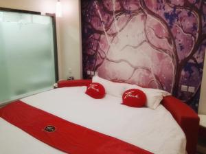 uma cama com duas almofadas vermelhas em cima em Thank Inn Chain Hotel Shandong ZaozhuangZhou North Tasi Road Government Affairs Center em Tengzhou