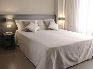 a large white bed in a bedroom with a window at Hotel Crystal in Marina di Pietrasanta