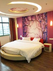 a bedroom with a large bed with a pink wall at Thank Inn Chain Hotel Jiangxi Yichun Fengxin East Fengchuan Road Huangni Lane in Fengxin