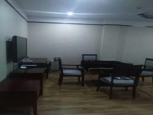 a room with chairs and tables and a tv at JUNYI Hotel Hebei Hengshui Shenzhou Government Building in Shen