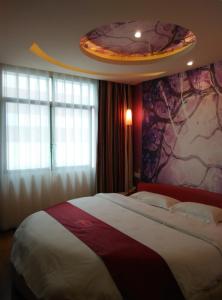 1 dormitorio con 1 cama grande y pared colorida en Thank Inn Chain Hotel Jiangxi Yichun Fengxin East Fengchuan Road Huangni Lane, en Fengxin