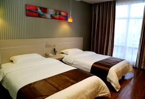 una camera d'albergo con due letti e una finestra di Thank Inn Chain Hotel Liaoning Anshan Haicheng Wanda a Yanjun