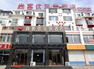 um grande edifício branco com escrita chinesa em Thank Inn Chain Hotel Shandong Binzhou Zhanhua Jinhai Six Road em Zhanhua