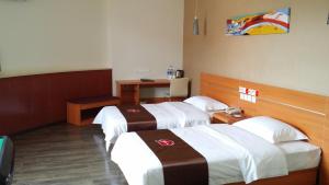 a hotel room with two beds and a desk at Thank Inn Chain Hotel Shanxi Lvliang County Taihe North Road in Houganquan