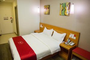 a hotel room with a bed and a table with a phone at Thank Inn Chain Hotel Gansu Jinchang Heya Road in Jinchang