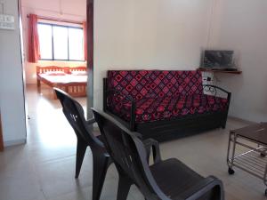 a living room with a couch and two chairs at Nivaant in Dapoli