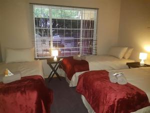 a hotel room with three beds and a window at The Highland Inn in Bethlehem