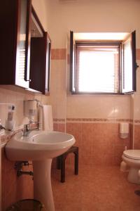 a bathroom with a sink and a toilet and a window at La Vista del Taburno in Montesarchio