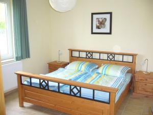 a bedroom with a wooden bed and two night stands at Comfortable Holiday Home in Satow near Baltic Coast in Satow