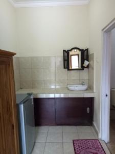 a small bathroom with a sink and a mirror at Sintya Homestay in Ubud