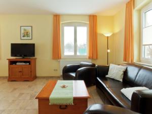 a living room with a couch and a tv at Comfortable Holiday Home in Satow near Baltic Coast in Satow