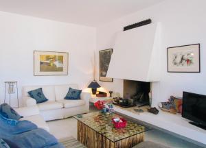 uma sala de estar com um sofá branco e uma televisão em Villa Waves em Agios Ioannis