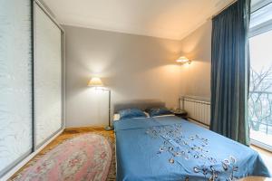 a bedroom with a blue bed and a window at Apartment near Olympic Stadium in Kyiv