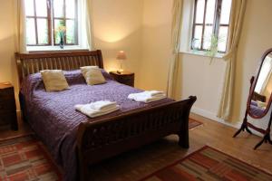 een slaapkamer met een bed met twee handdoeken erop bij Church Farm Barns in Stratford-upon-Avon