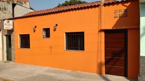 an orange building with two windows and a door at Pousada Pai Nosso in Aparecida