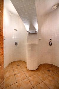 a bathroom with a tile floor and tile walls at Theatrino Hotel in Prague