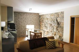 - un salon avec un canapé et un mur en pierre dans l'établissement Casa Joao Vilar, à Campo do Gerês