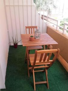 a wooden table and two chairs on a balcony at Apartamento a 5 min de la playa y el centro in Almería