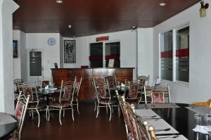 Un comedor con mesas y sillas en un restaurante. en Coolborn Apartment, en Nuwara Eliya