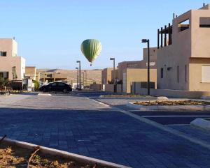 a hot air balloon flying over a parking lot at Yvonne Hostel Sde Boker in Midreshet Ben Gurion