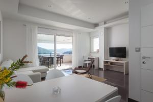 a living room with white furniture and a view of the ocean at Apartment Pasadur Lastovo in Lastovo