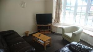 a living room with a couch and a tv and a chair at Tudor Lodge in Scunthorpe
