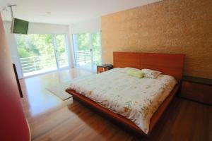 a bedroom with a large bed with a wooden headboard at Casa de Paredes Secas by Gerês Casas in Amares +32 photos