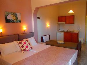 a bedroom with a bed and a small kitchen at Maria Studios in Patitiri