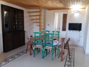 a dining room with green chairs and a table at Casa salento in Corsano