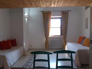 a room with two beds and two stools and a window at Casa salento in Corsano