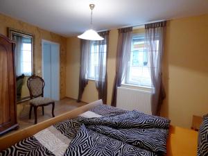 1 dormitorio con 1 cama, 1 silla y ventanas en Relaxen im alten Winzerhaus Fewo EG, en Rech