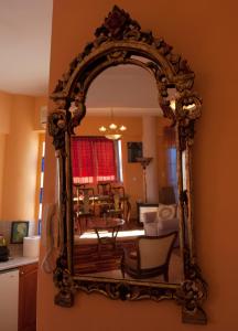 an ornate mirror hanging on a wall in a living room at Semiramis Apartments in Ierapetra