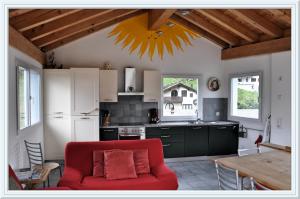 a living room with a red couch in a kitchen at Chesa Tre Piz, Maloja in Maloja