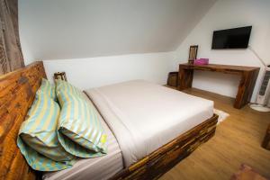 a bedroom with a couch with pillows and a television at At Samui Haus in Lipa Noi