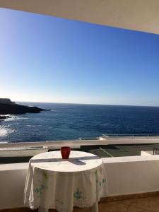 un jarrón sentado en una mesa en un balcón con el océano en El Ancla, en Callao Salvaje