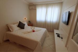 a bedroom with a bed with a teddy bear on it at Casa do Artista a 60m do mar, piscina, 4 quartos in Bombinhas