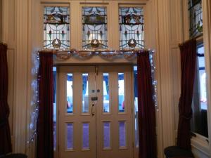 Morangie Hotel Tain في تاين: الباب الأمامي مع أضواء عيد الميلاد عليه