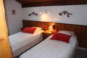 a bedroom with two beds with red pillows at La Gelinotte in Les Contamines-Montjoie