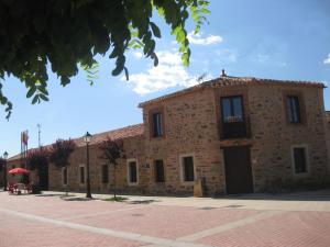 Casa Rural Las Águedas في Murias de Rechivaldo: مبنى حجري كبير عليه علم