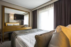 アンカラにあるSc Inn Hotel Ankaraのベッドと大きな窓が備わるホテルルームです。