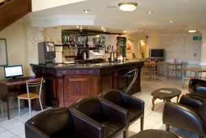 a bar in a restaurant with leather chairs at The Ashley Hotel in Hale