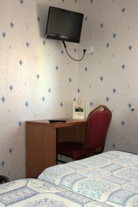 a bedroom with a desk and a tv on the wall at A L'ancienne Poste in Battenheim