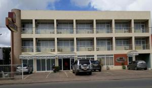 a large building with cars parked in a parking lot at Varanda Hotel in Arapiraca