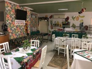 a dining room with white tables and white chairs at Varanda Hotel in Arapiraca