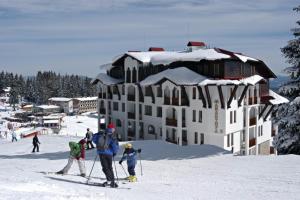 a group of people on skis in front of a building at Grand Monastery 3 Apartment 10 in Pamporovo